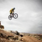 Rowerzysta na MTB skacze na szlaku w terenie, przykład jazdy na górskim rowerze